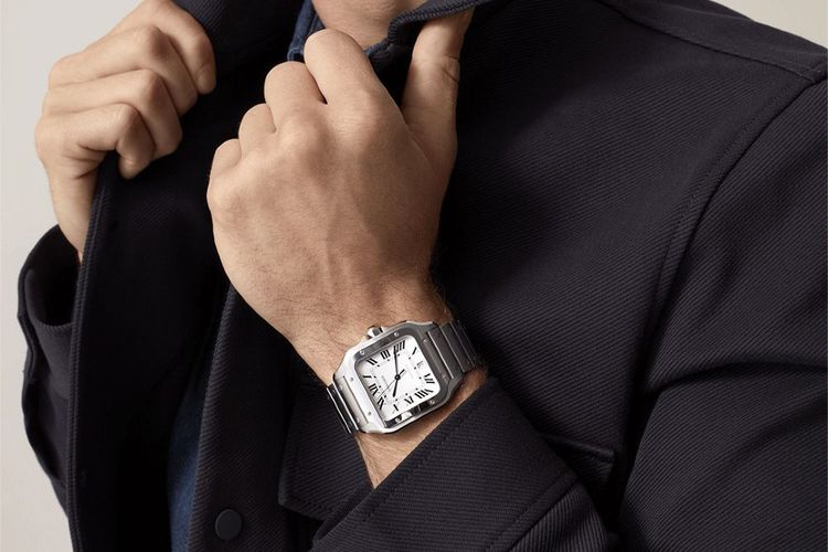 new shiny steel Santos de Cartier watch worn by a man in a black suit